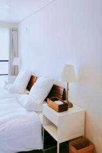 a bedroom with a white bed with a table with a lamp at Niseko White Villas1 in Niseko