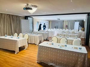 a room with tables and chairs with people in the background at St Eve Lodge & Spa in Bloemfontein