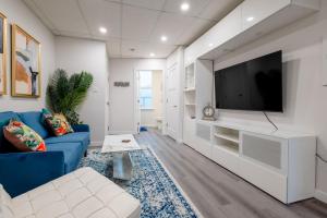 a living room with a blue couch and a flat screen tv at Victoria's Lookout in London