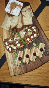 un plateau de découpe en bois avec quatre tranches de pizza dans l'établissement Domestic House Lola, à Vukovar