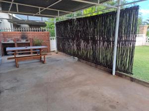 un banco de picnic en un patio con una pared de ladrillo en Albert's Nest, en Kimberley