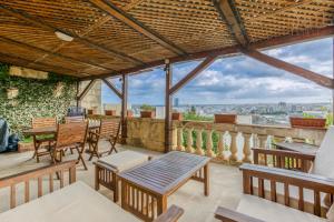 Stunning 4BR Villa with Huge Terrace in Kappara by 360 Estates في إيل جزيرا: فناء به طاولات وكراسي ومطل على المدينة