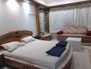 een slaapkamer met een groot bed en een bank bij Luxury Studio with bathtub in Mumbai