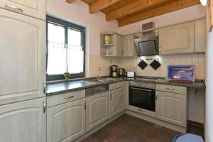 a kitchen with white cabinets and a sink and a window at Maribell Appartement in Jabel