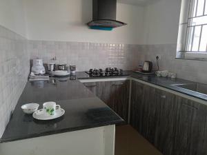 a kitchen with two cups and a plate on a counter at Alite Enclaves Fully furnished apartments in Trichūr