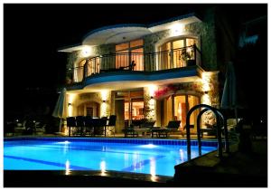 a large house with a swimming pool at night at Villa Valo in Kalkan