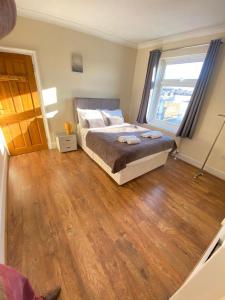 a bedroom with a bed and a large window at 2 Bedroom Apartment 2 Min Walk to Station - longer stays available in Gravesend