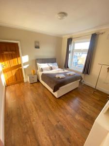 1 dormitorio con cama y ventana grande en 2 Bedroom Apartment 2 Min Walk to Station - longer stays available, en Gravesend
