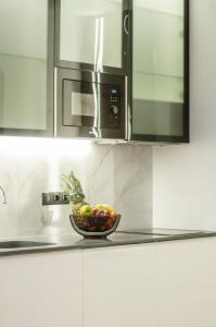 a bowl of fruit on a kitchen counter with a microwave at Mountain Residence Apartments & Chalet in Bukovel