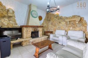 - un salon avec un mur en pierre et une cheminée dans l'établissement Stunning 4BR Villa with Huge Terrace in Kappara by 360 Estates, à Il-Gżira