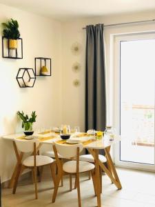 ein Esszimmer mit einem Tisch, Stühlen und einem Fenster in der Unterkunft Apartment Aurora in Opatija