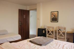 a bedroom with a bed and two chairs and a desk at KAJI HOME in Pātan