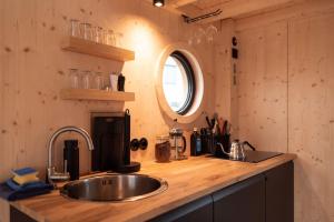 a kitchen counter with a sink and a mirror at Hausboot OFF im Diamantgraben an der Elbe in Hamburg
