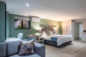 een slaapkamer met een bed en een bank bij Pezula Beachfront Splendour - 5 bedroom in Knysna +39 foto's