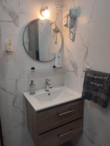 La salle de bains est pourvue d'un lavabo et d'un miroir. dans l'établissement HÉBERGEMENT au LOGIS, à Sougé-le-Ganelon