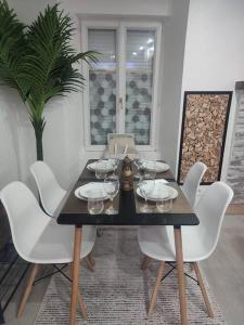 stół jadalny z białymi krzesłami i okularami w obiekcie HÉBERGEMENT au LOGIS w mieście Sougé-le-Ganelon