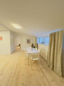 comedor con mesa blanca y sillas en aday - Holiday Apartment in the heart of Frederikshavn, en Frederikshavn