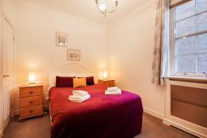 um quarto com uma cama vermelha com duas toalhas em William Morris on the historic Shambles York em York