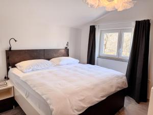 een slaapkamer met een groot bed en een raam bij Chic Spacious Apartment Surrounded by Nature Near Opatija in Matulji