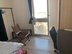 a room with a chair and a table and a window at Une Chambre simple accès direct Aéroport d'Orly T4 in Orly