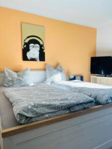 Schlafzimmer mit einem Bett mit einem Bild eines Gorillas in der Unterkunft StrandLiebeDuhnen in Cuxhaven