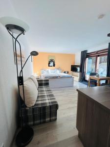 ein Schlafzimmer mit einem Bett und einem Sofa mit einer Lampe in der Unterkunft StrandLiebeDuhnen in Cuxhaven