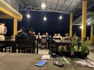 a group of people sitting at tables in a restaurant at Rinjani Golden in Senaru