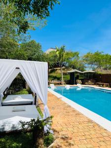 una piscina con tenda e sedie accanto ad essa di Mangal Beach Lodge a Vilanculos