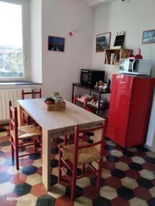 uma cozinha com uma mesa e um frigorífico vermelho em Il Giardino di Marzo Guest House em Monti di Licciana Nardi