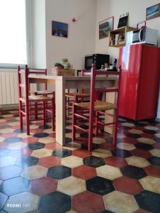 cocina con mesa, sillas y nevera en Il Giardino di Marzo Guest House, en Monti di Licciana Nardi