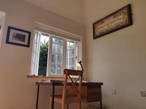 - un bureau avec une chaise devant une fenêtre dans l'établissement Smugglers Lodge at Ventnor Botanic Garden, à Ventnor