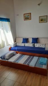 een slaapkamer met een bed met blauwe lakens en een raam bij La Familia in Posadas
