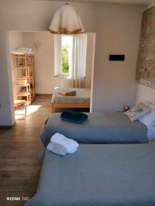 Monti di Licciana Nardi的住宿－Il Giardino di Marzo Guest House，客房设有两张床和窗户。