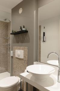 a bathroom with a white sink and a toilet at Paragon Apartments in Frankfurt/Main