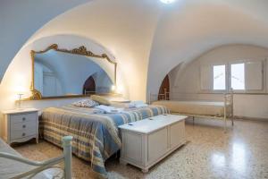 1 dormitorio con cama y espejo grande en La casa dei nonni, en Cisternino