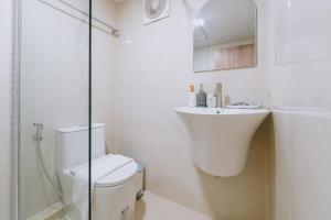 a white bathroom with a toilet and a sink at Sea Sand See Sky Beach Front Resort in Phuket Town