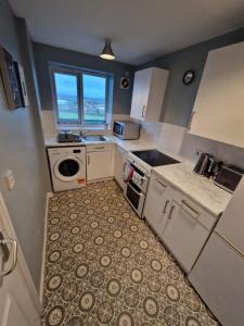 a small kitchen with a sink and a stove at 1-Bedroom Flat Close to Manchester Airport in Handforth