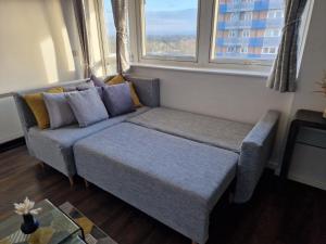 a couch in a living room with a window at 1-Bedroom Flat Close to Manchester Airport in Handforth