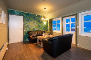a living room with a leather couch and a table at West-End Apartment in Andenes