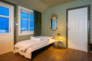 a bedroom with a bed in a room with a window at West-End Apartment in Andenes