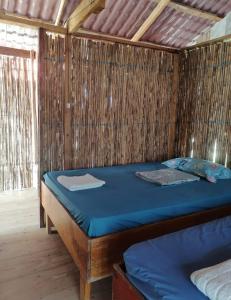 a bedroom with a bed in a straw hut at Cabañas sobre el mar en San Blas Narasgandub. in Nusatupo