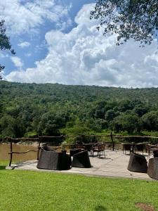 - un ensemble de tables et de chaises sur une terrasse avec vue dans l'établissement Wilderness Seekers Ltd Trading As Mara River Camp, à Aitong