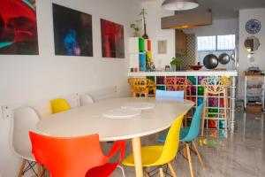 a dining room with a white table and colorful chairs at Villa Jo - stunning front line beach house. in L'Ametlla de Mar
