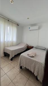 a room with two beds and a window at Departamento El Caminante in Oberá