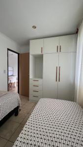a bedroom with two beds and a white cabinet at Departamento El Caminante in Oberá