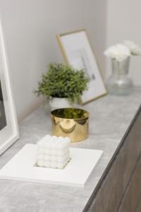 a pile of marshmallows on a plate next to a plant at White & Gold Marble Apartment Łódź Fabryczna by Renters in Łódź