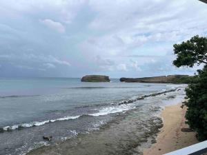 a beach with some rocks in the water at Huellas in Arecibo