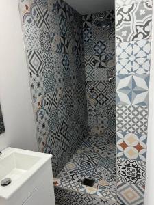 a bathroom with a shower with a sink and tiles at Huellas in Arecibo