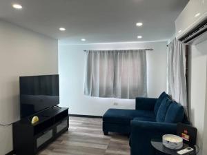 a living room with a blue couch and a tv at Huellas in Arecibo