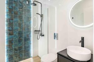 a bathroom with a sink and a glass shower at Casa Blanca Tenerife in Playa de San Juan